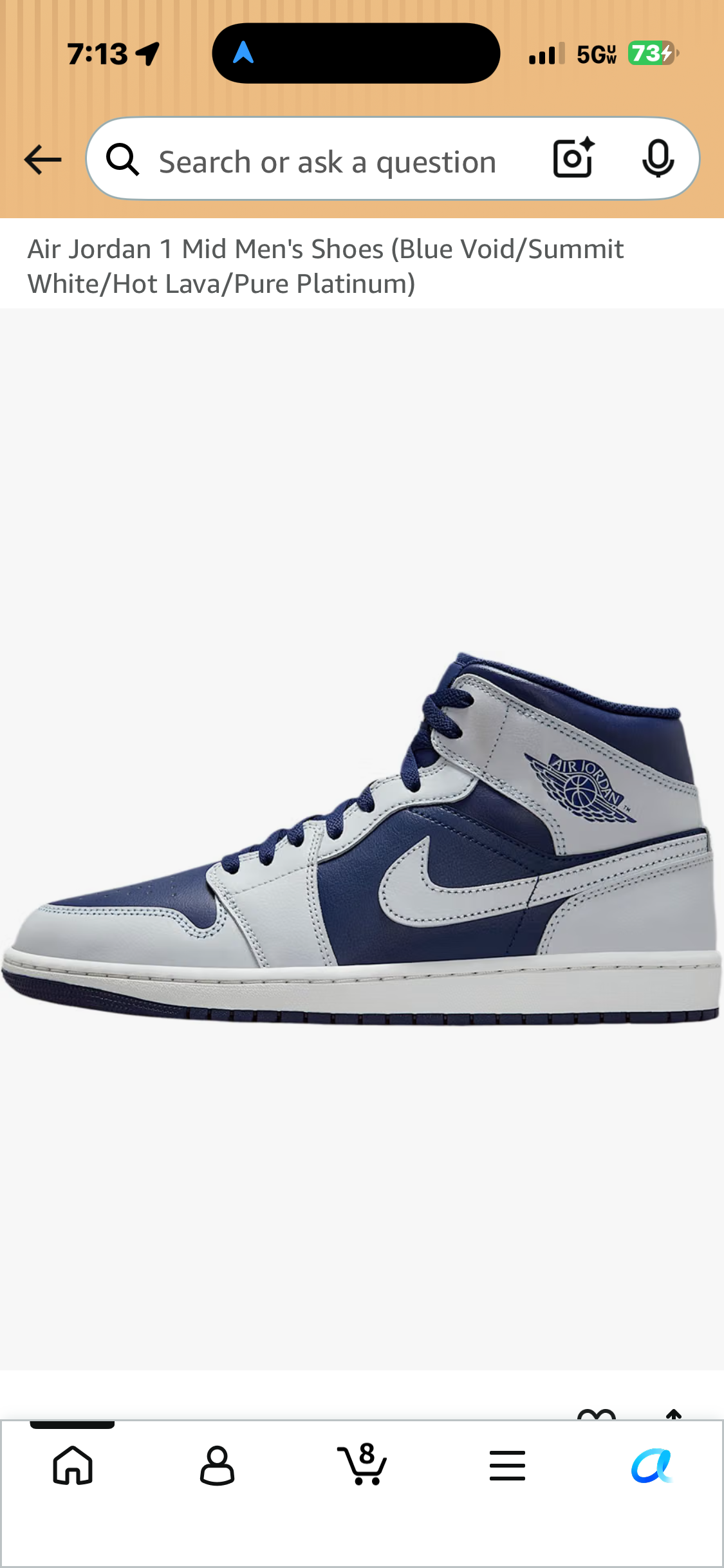 Air Jordan 1 Mid sneaker with navy blue and light gray panels, light gray Swoosh, and Air Jordan Wings logo